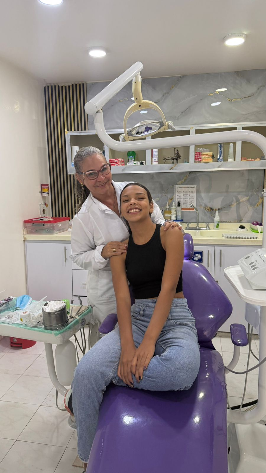 Paciente sonriendo junto a la profesional de odontología después de su atención